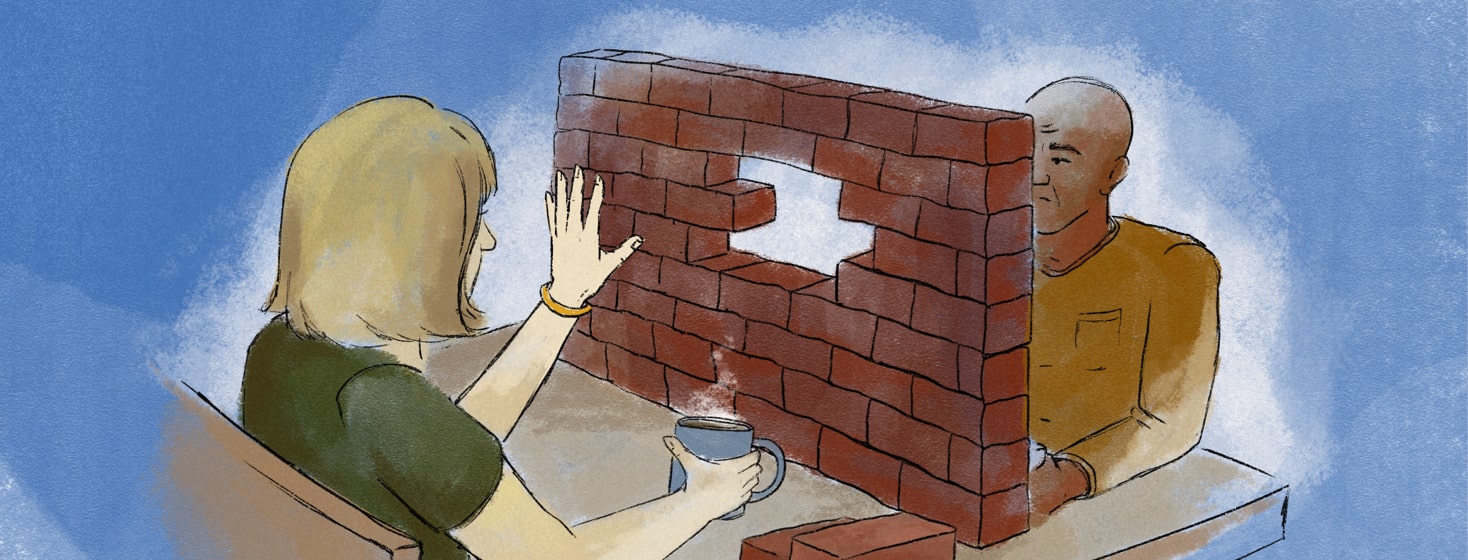 Two people having coffee with a brick wall between them on the table